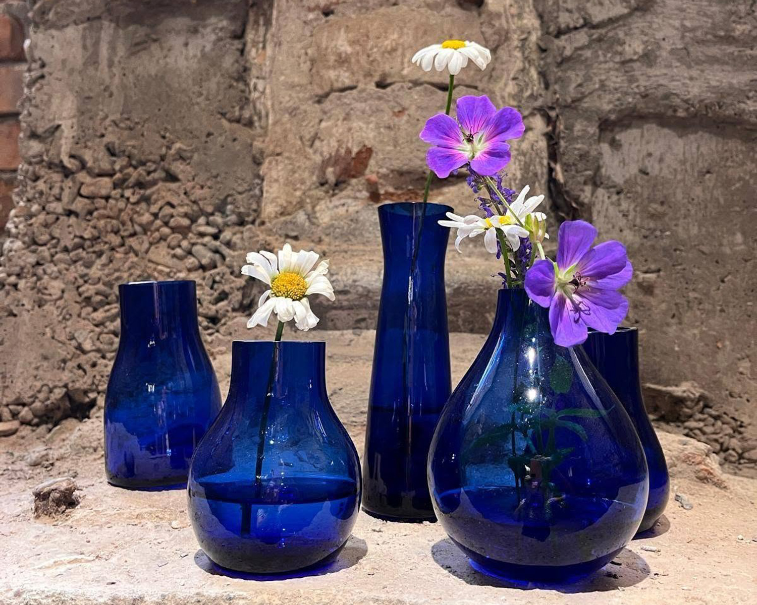 Handblown blue glass vases with wildflowers